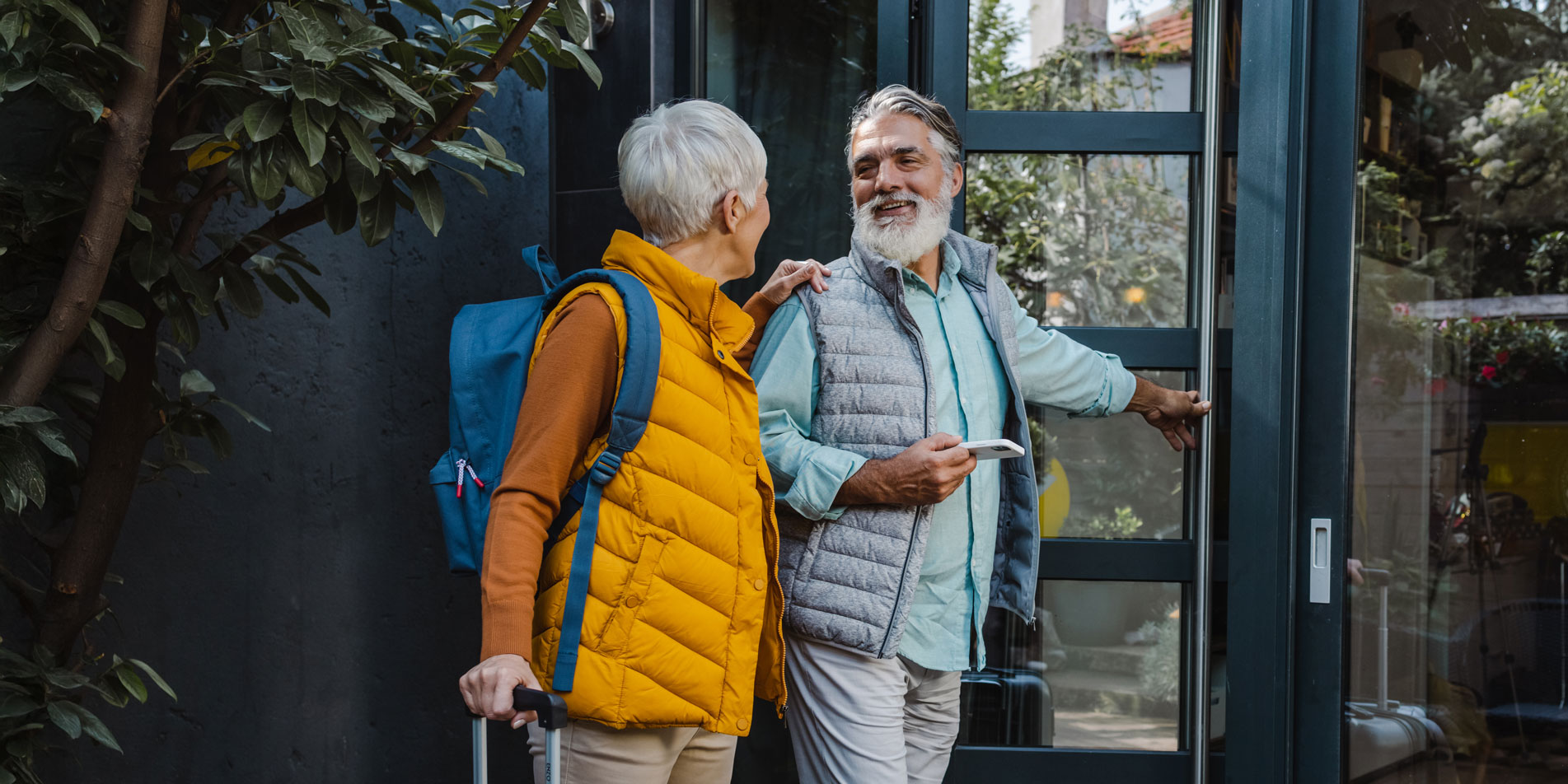 older couple with backpack and suitcases